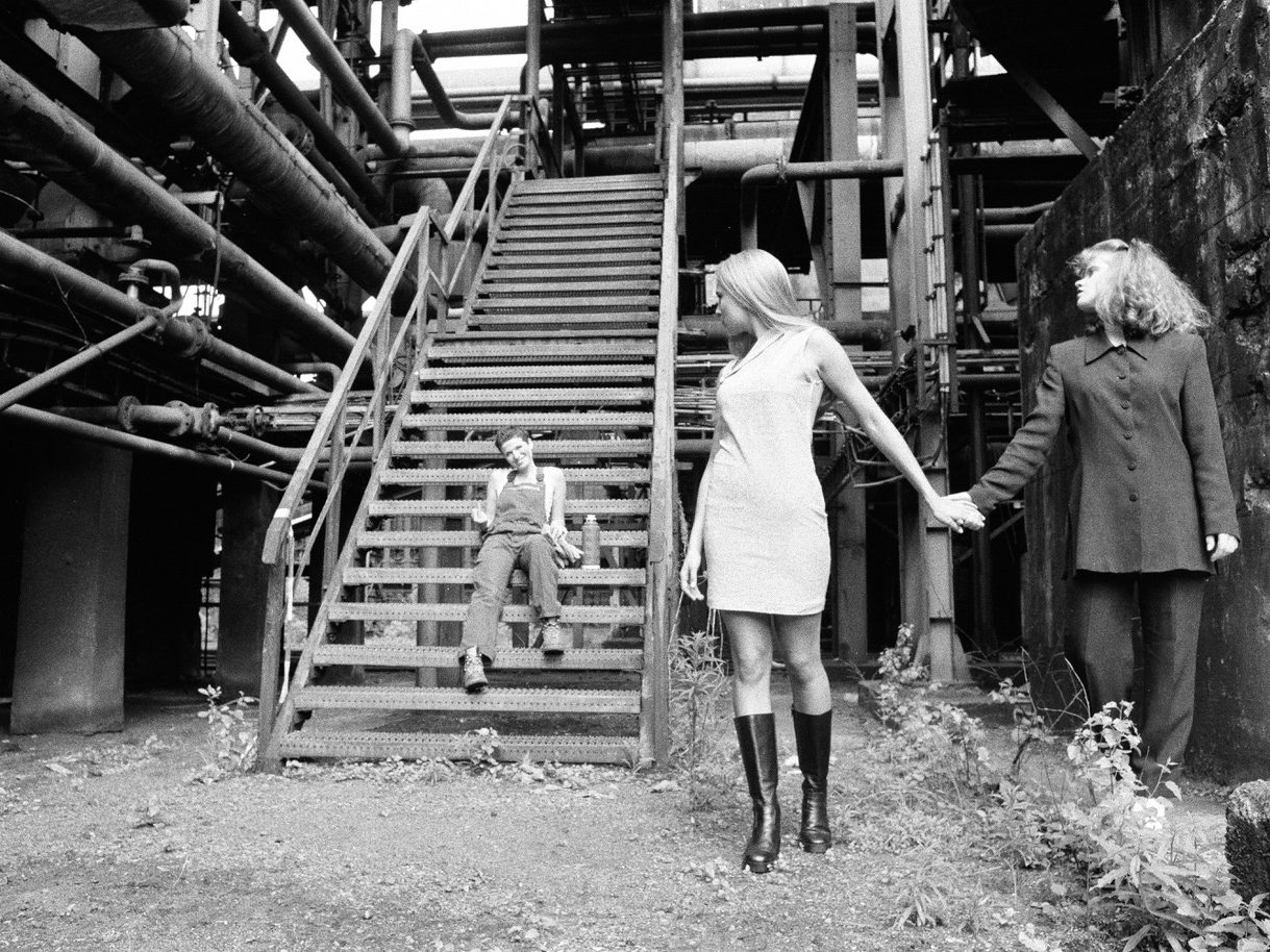 Mutter Eine Person mit einem Tuch, das über den Kopf gebunden ist, in einer monochromen Szenerie.